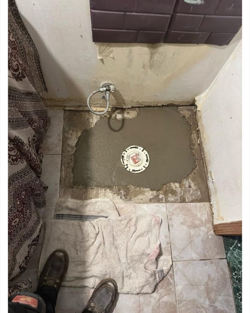 The same floor patched in fresh concrete with a new closet flange set flush