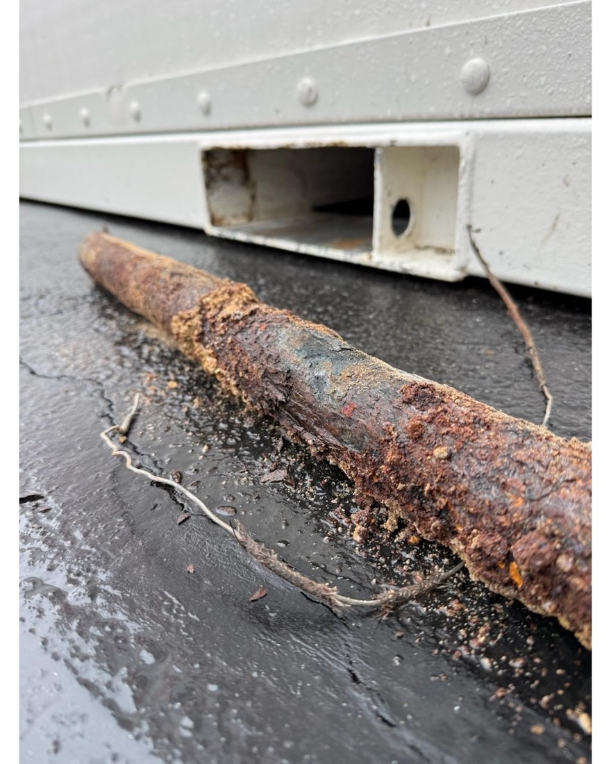 Badly corroded metal pipe removed from a job and laid on the pavement