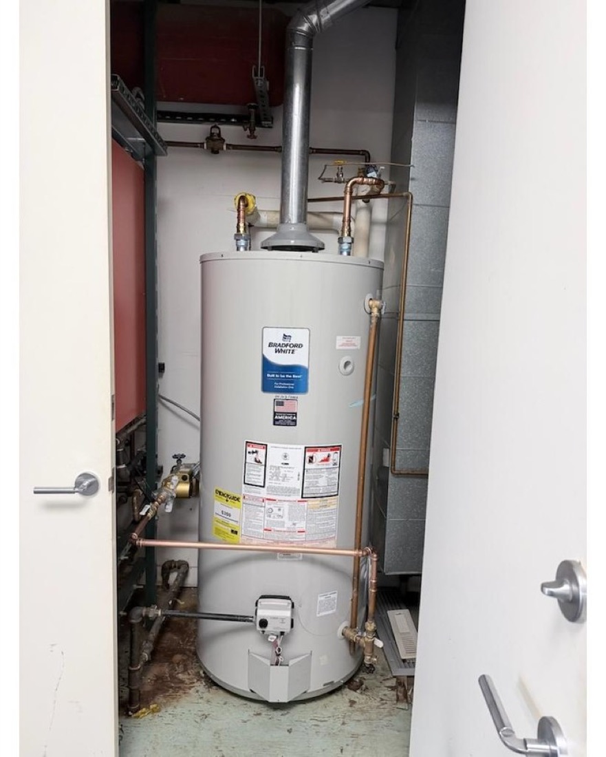 Newly installed water heater with fresh copper connections in a basement